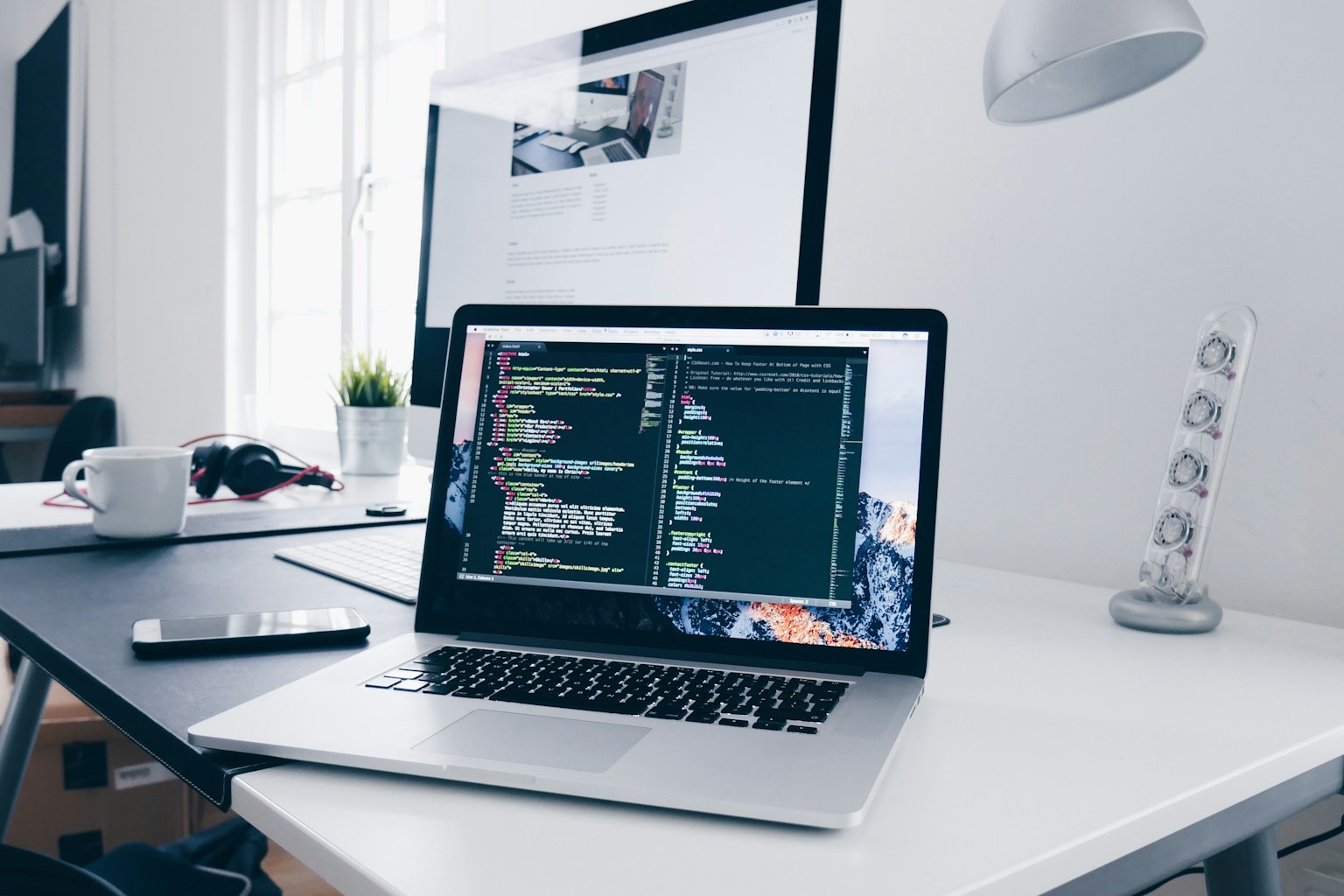 میز کار توسعهدهندهٔ وب با لپتاپ و محیط برنامهنویسی
